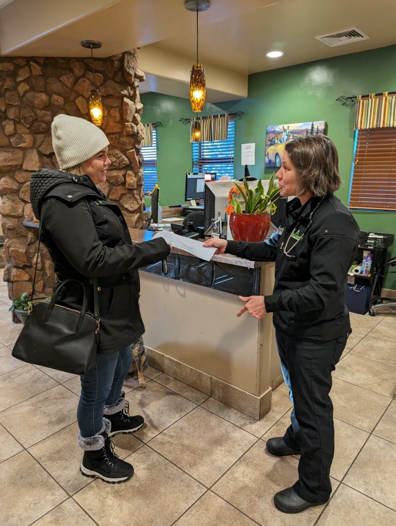 vet handing off dog prescription to owner