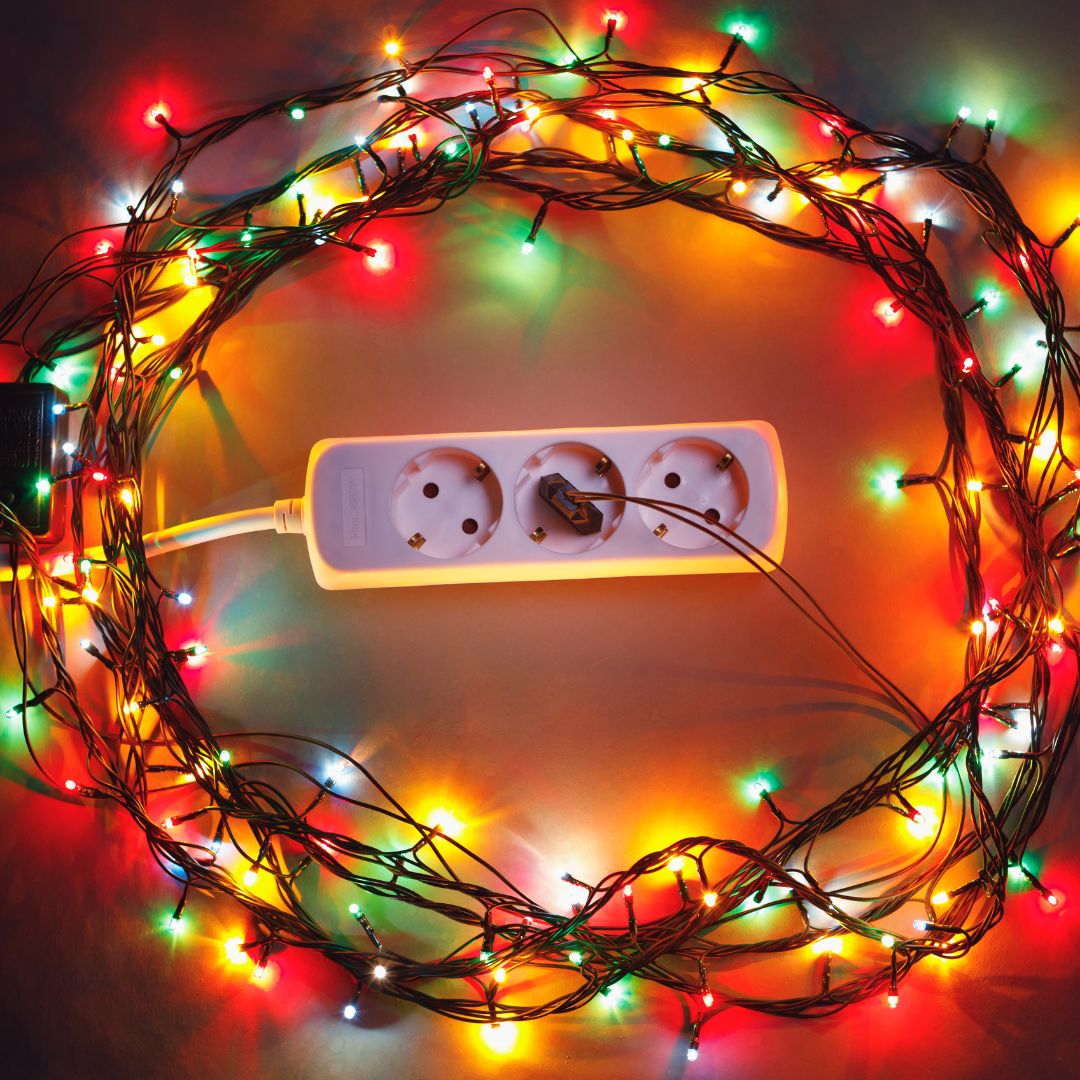 electrical plug with christmas lights around in a circle lit up