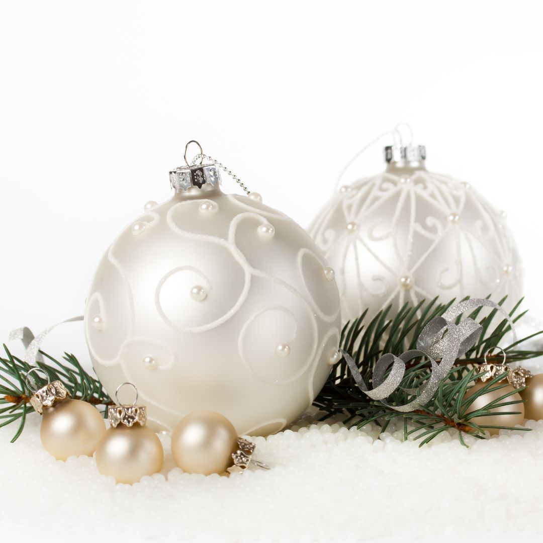 white chrismas ornaments with some pearls and pine foliage around the base